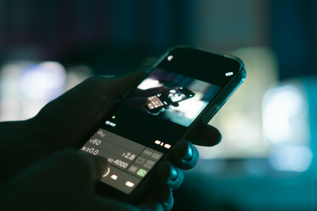 Close-up of a hand holding a smartphone browsing a streaming app